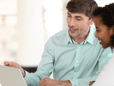 Employee helping client on laptop 772x579.png